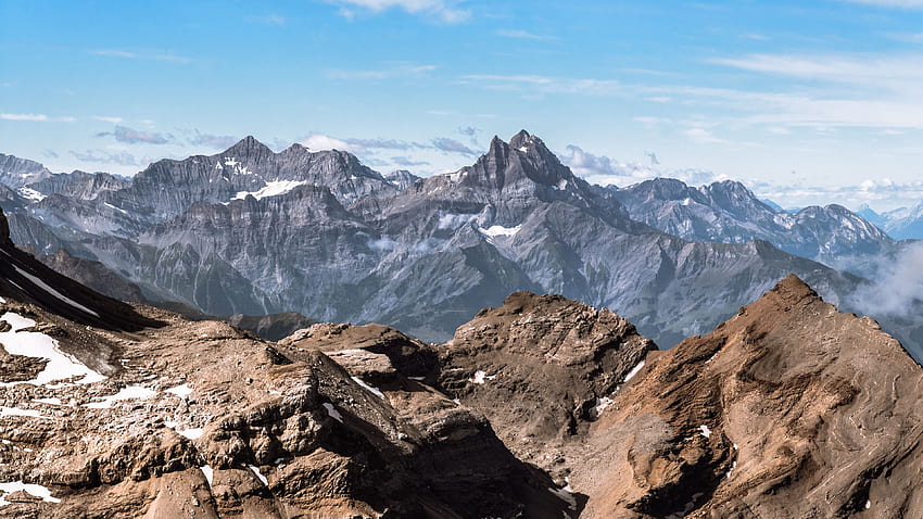 Montañas rocosas con nieve bajo un cielo azul durante el día Naturaleza