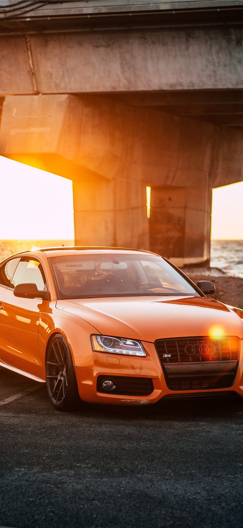 оранжево Audi купе, паркирано на сив бетонен път HD тапет за телефон