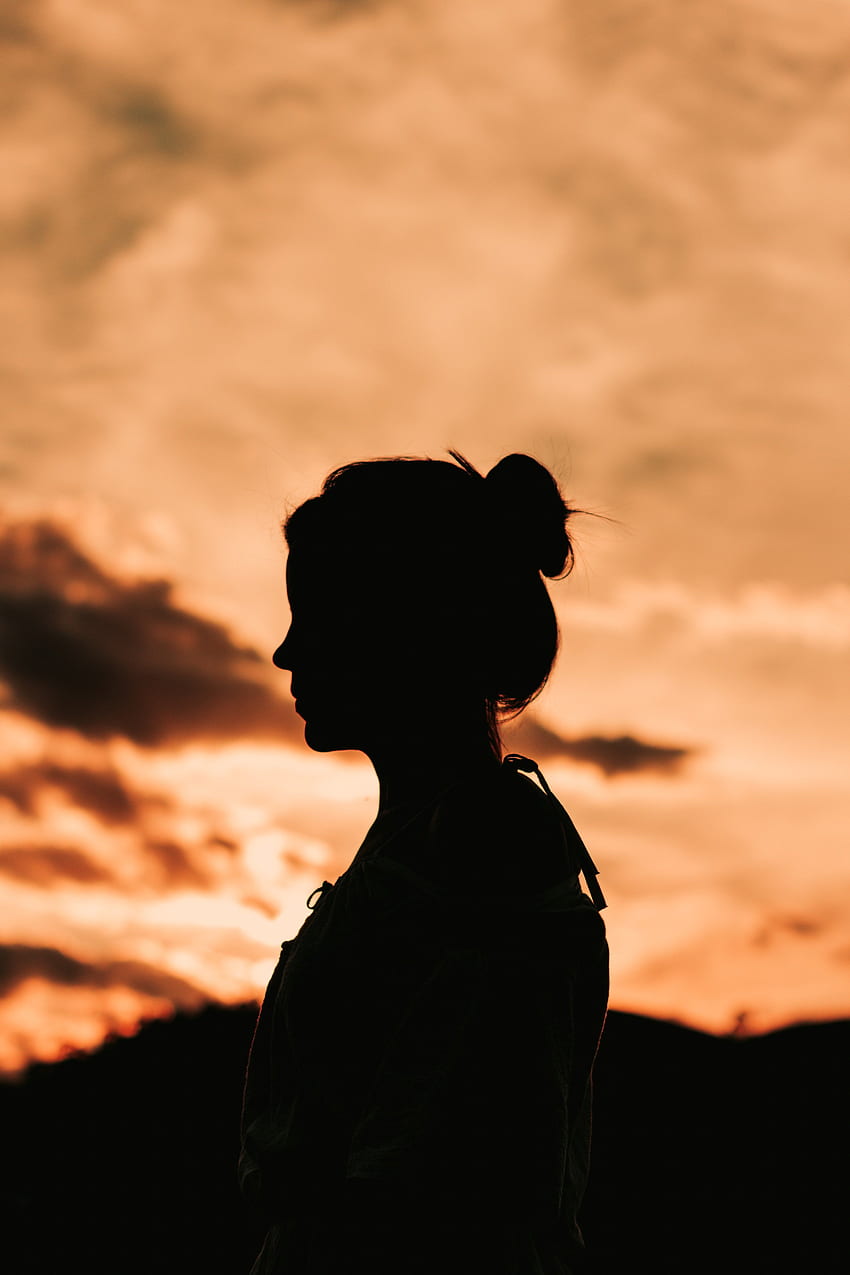 / silhouette of a woman standing alone under an orangesunset, silhouette_ HD phone wallpaper