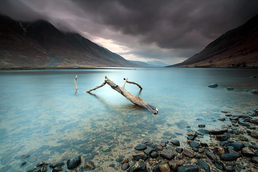 Solitude, sea, driftwood, clouds, sky, mountains, rocks, stormy HD wallpaper