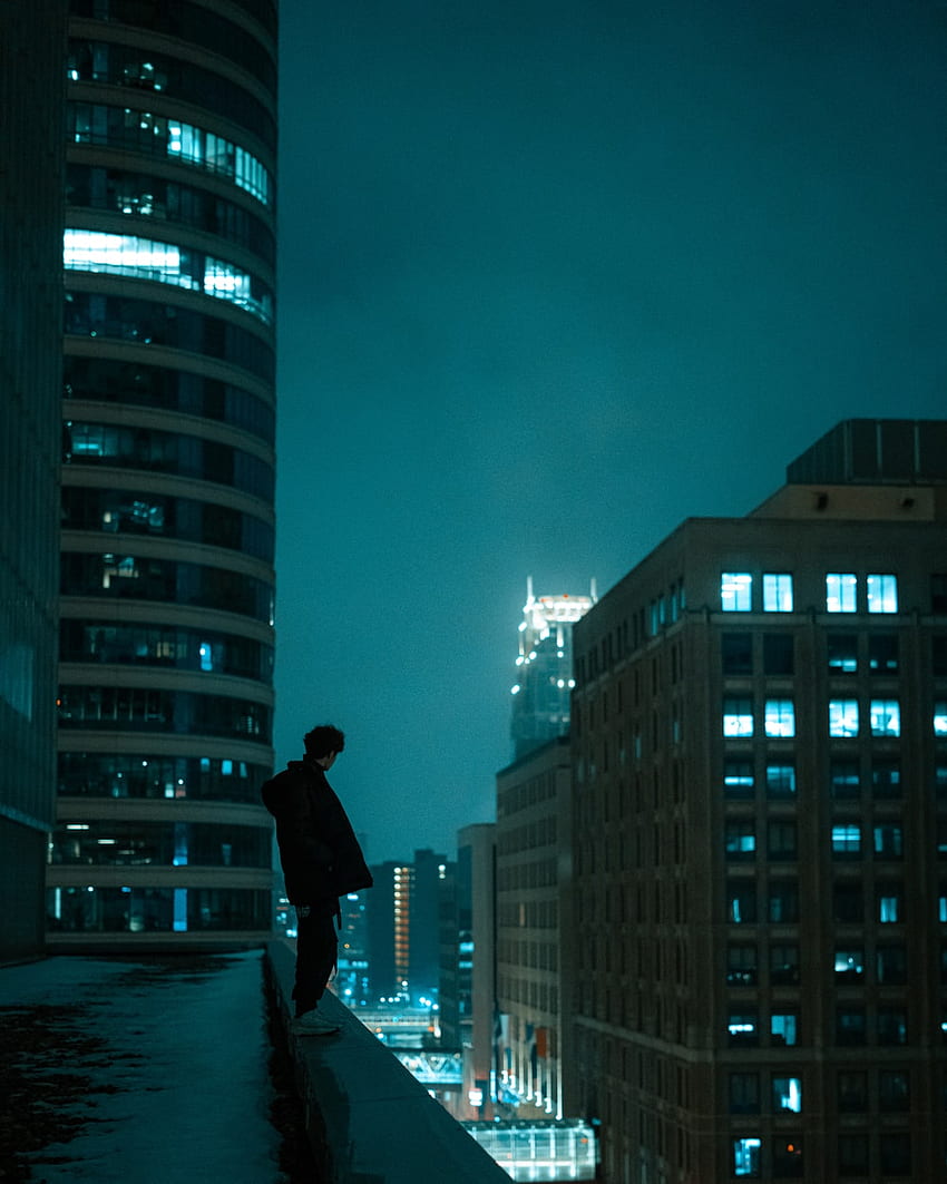 Uomo in piedi sul tetto che osserva la città con grattacieli durante la notte - Edificio, tetto di notte Sfondo del telefono HD