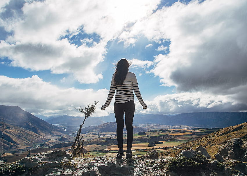 Young woman standing alone above a mountain range by Maximilian Guy McNair MacEwan HD wallpaper