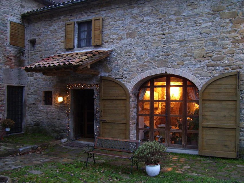 Maison de famille à Noël - Italie, arrière-cour, banc, pin pot, belle porte de décoration de Noël, grande fenêtre éclairée, maison en pierre Fond d'écran HD