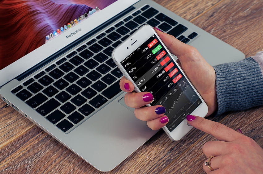 eine Person, die Börsenkurse auf ihrem iPhone überprüft, NYSE HD-Hintergrundbild