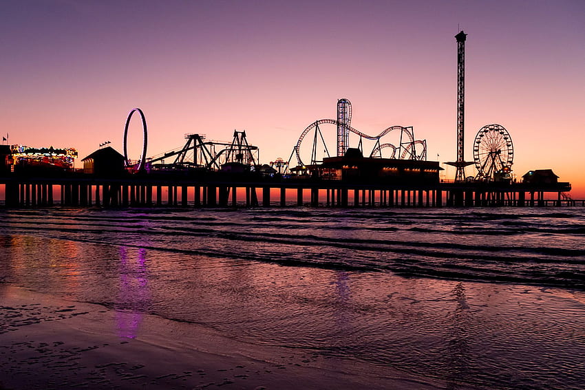 Die Morgensonne silhouettiert den Historic Pleasure Pier am Strand von Galveston, Texas. Sehen Sie mehr HD-Hintergrundbild