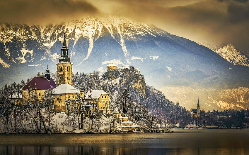 Lac de Bled en hiver, île, slovénie, nuages, ciel, église, maisons, montagnes Fond d'écran HD