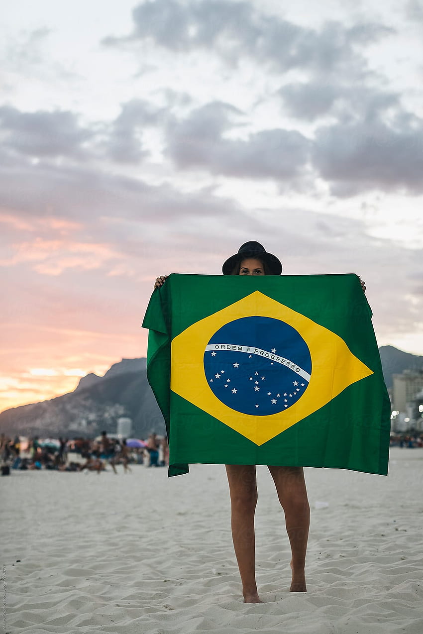 Рио де Жанейро. Бразилия. Жена, играеща с бразилско знаме на плажа при залез от Мауро Григоло - Жена, Бразилия HD тапет за телефон