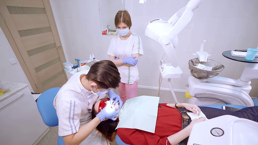Tıbbi diş muayenehanesi. Hareketli geniş açıda pürüzsüz panorama kamerası. Doktor müşteriyi sandalyeye alır. Stok Video Görüntüsü - VideoBlocks HD duvar kağıdı