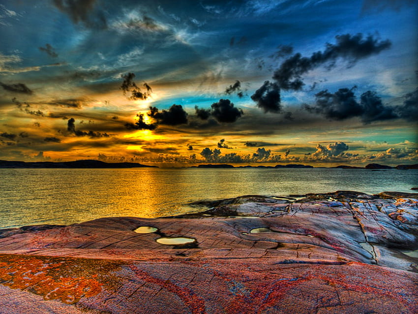 Scrambled sky, blue, black, aqua, gold, rocks, dark, shore, clouds, sky, water, sunset HD wallpaper