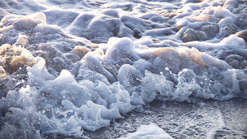 Vista de cerca de la naturaleza de salpicaduras de agua de espuma de mar fondo de pantalla