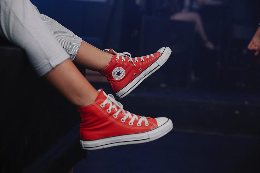 Persona che indossa scarpe da ginnastica alte Converse All Star rosse · Azione Sfondo HD