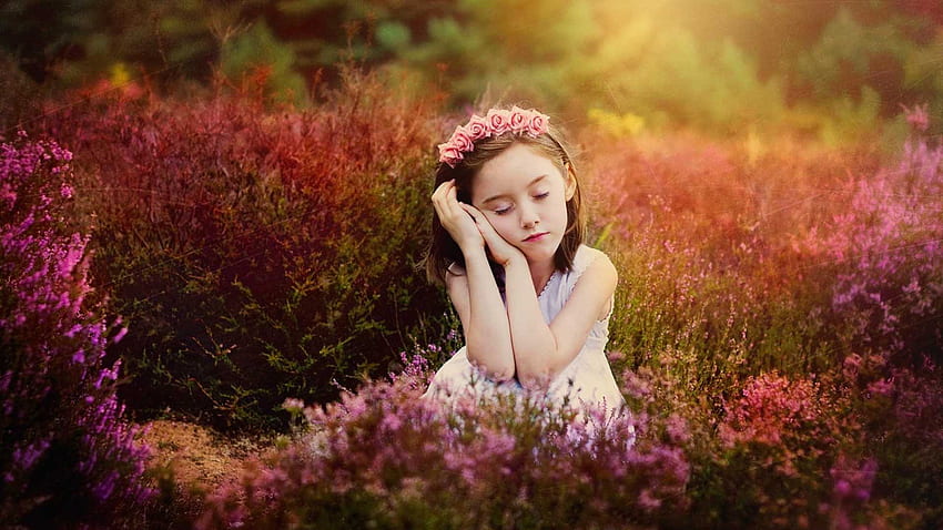 目を閉じてかわいい女の子はかわいい白いドレスを着て紫の花のフィールドの背景に座っています。 高画質の壁紙