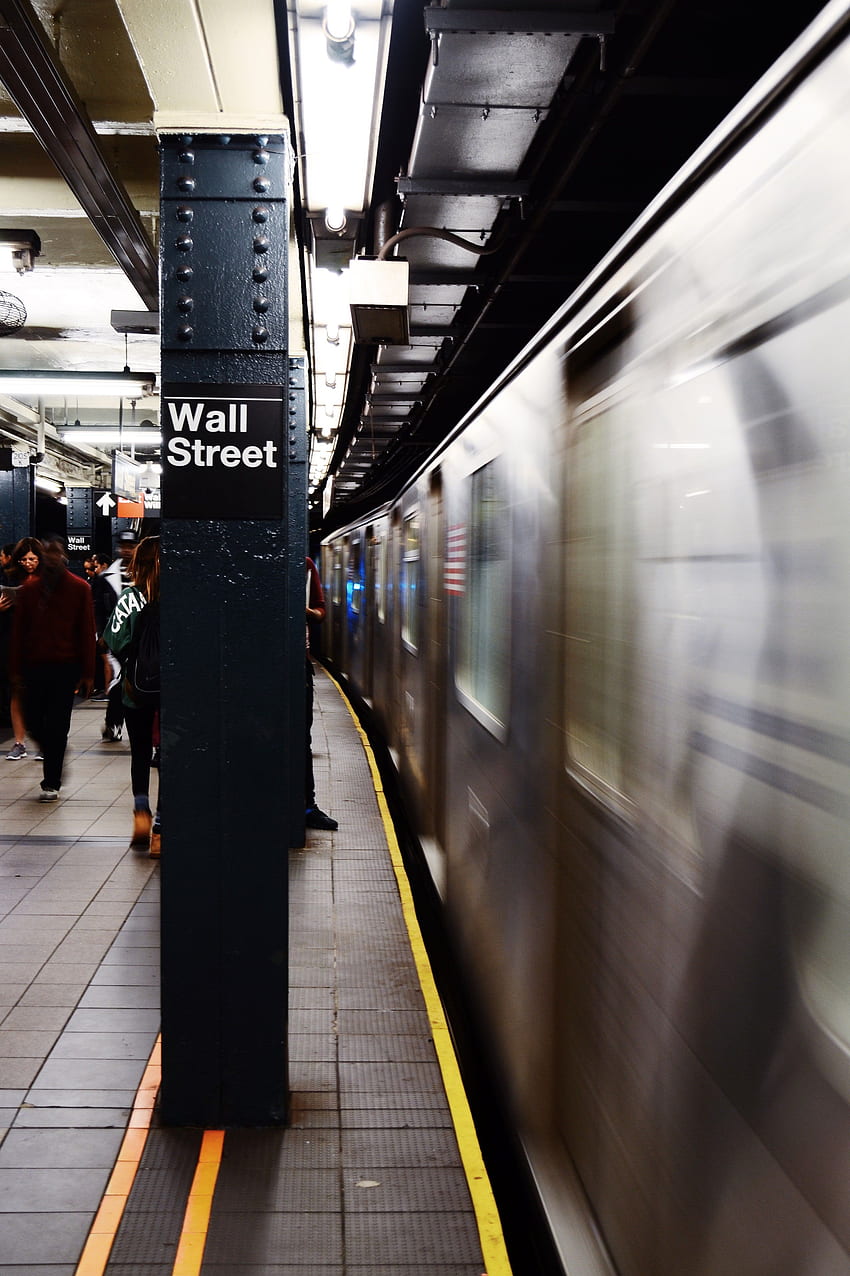 Un tren en movimiento en el andén de la estación de metro de Wall Street en Nueva York. Comercio de acciones, comercio de acciones, dinero comercial fondo de pantalla del teléfono