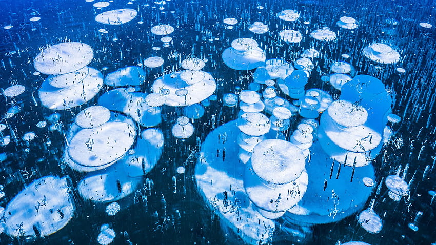 Ice bubbles in the frozen Lago Bianco Lake at Bernina Pass, Engadin, Grisons, Switzerland. Windows 10 Spotlight HD wallpaper