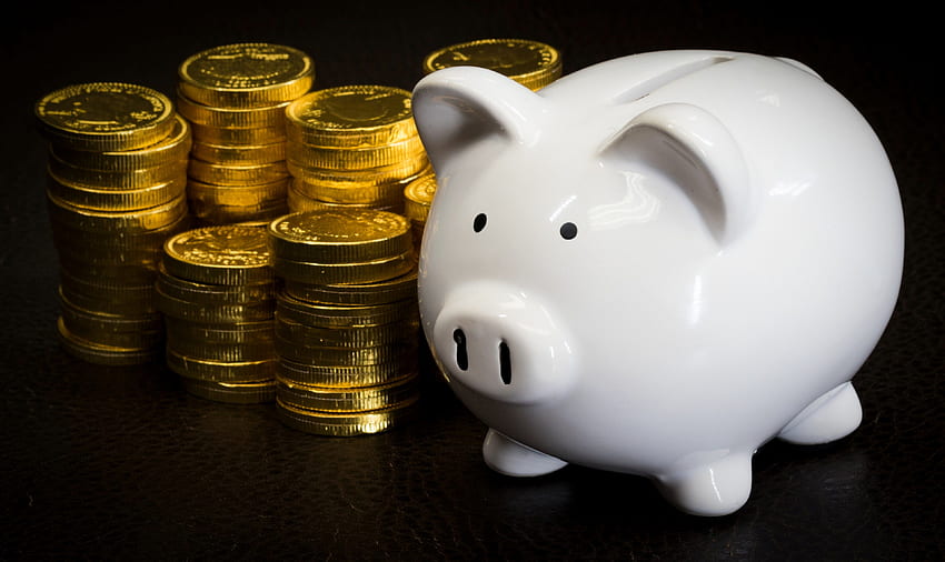 a white piggy bank next to a bunch of stacked gold coins piggy HD wallpaper