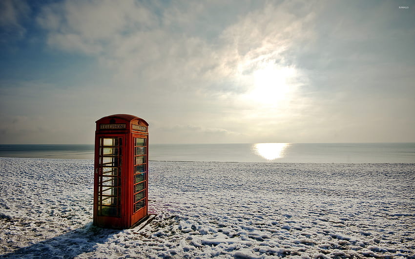 Cabina de teléfono roja en una playa de invierno jpg fondo de pantalla