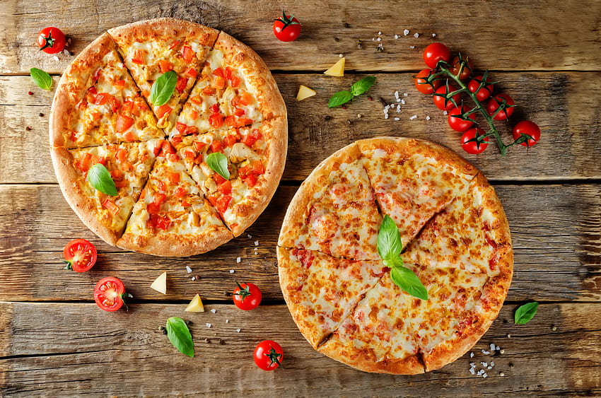 Two pizzas with cheese and bell peppers on a table with tomatoes and - HD wallpaper