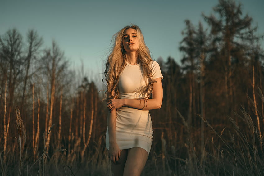 Blondes Mädchen im weißen Kleid, Sonnenstrahlen im Gesicht, im Freien HD-Hintergrundbild