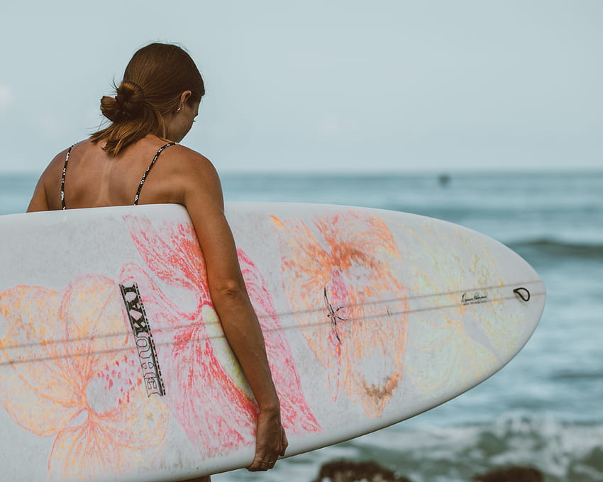 Mujer en tabla de surf rosa y blanca en el mar · Stock, tablas de surf coloridas fondo de pantalla
