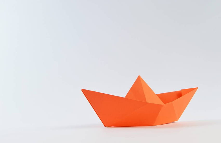Pomarańczowa papierowa łódź na białej powierzchni · Zapas Tapeta HD