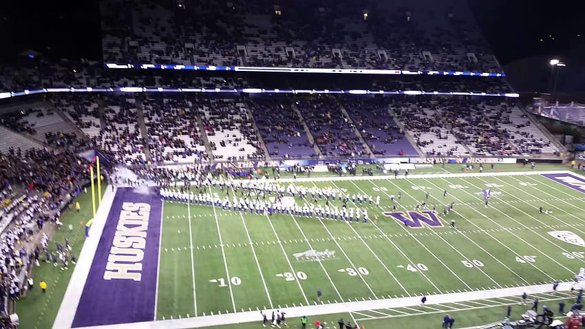 2015 University of Washington Football Team stürmt das Feld vor dem Spiel HD-Hintergrundbild