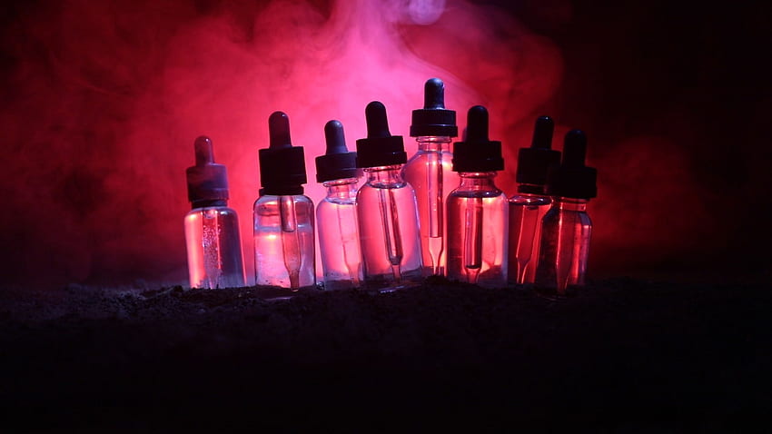 Vape concept. Smoke clouds and vape liquid bottles at dark background ...