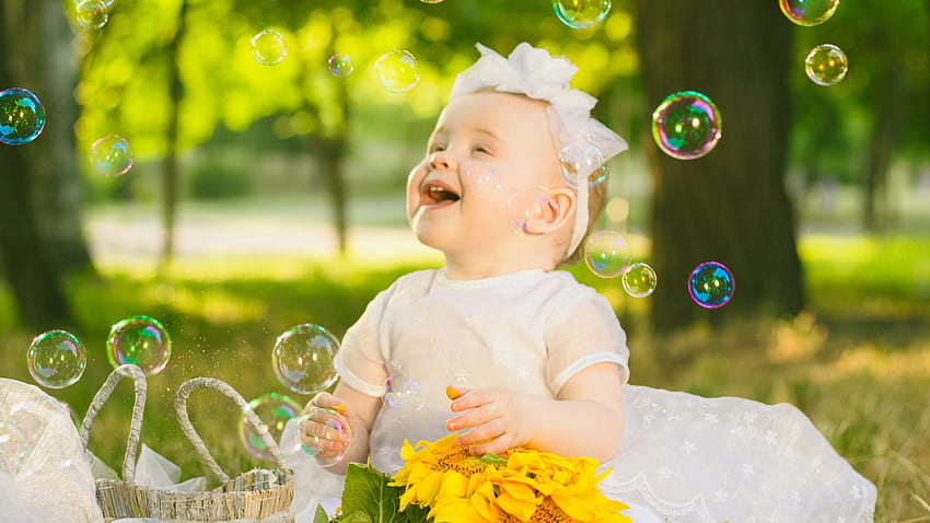 Cute Girl Baby sta giocando con le bolle indossando un abito bianco in sfocatura Bokeh verde Carino Sfondo HD