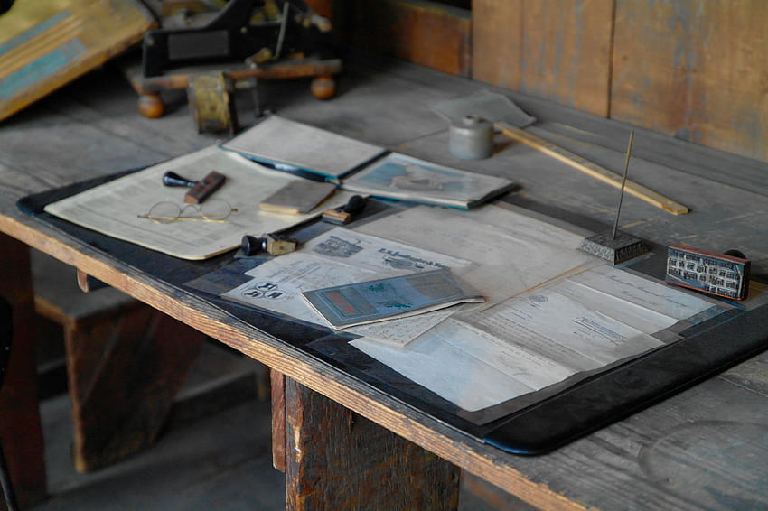 / Dokumente und Karten auf einer unordentlichen Werkbank, Brillenpapier auf einem Holztisch HD-Hintergrundbild