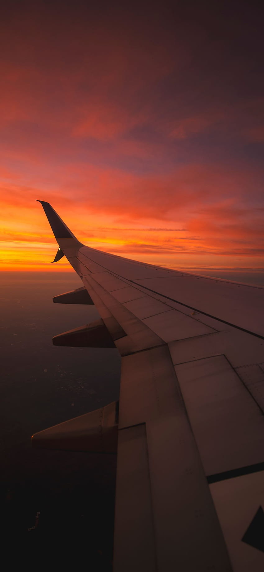 Blick auf den Sonnenuntergang aus dem Fenster eines Flugzeug-iPhone HD-Handy-Hintergrundbild