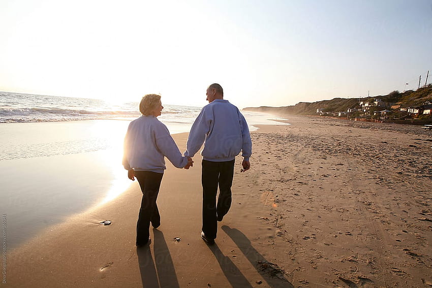 手を繋いで海辺を歩く老夫婦 高画質の壁紙
