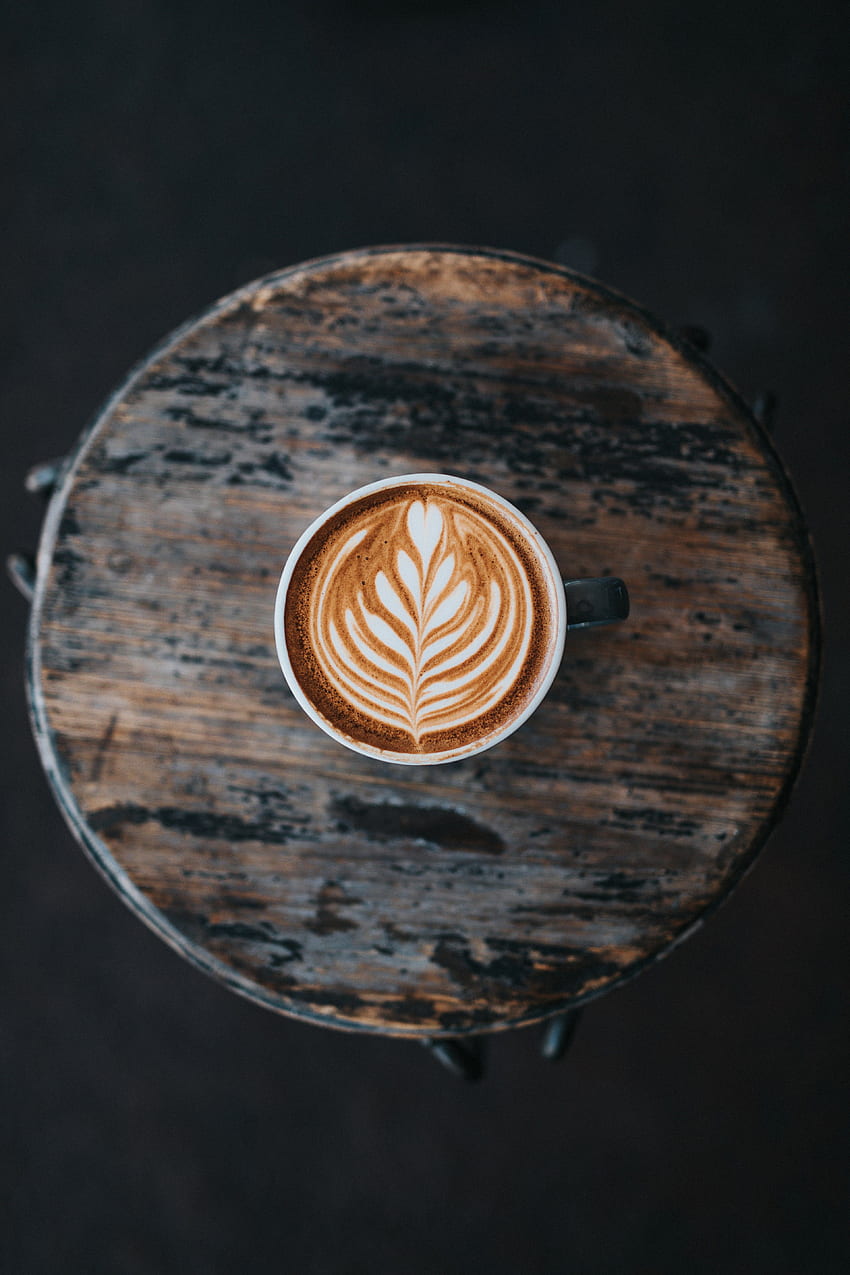 / kawa latte art oglądana z góry w filiżance na drewnianym stole przy dwóch pistoletach espresso, espresso z latte art Tapeta na telefon HD