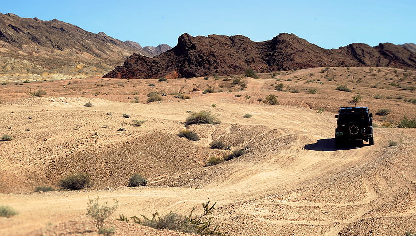 / jeep truck drives through rough terrain of the desert in las vegas, black jeep desert vegas HD wallpaper