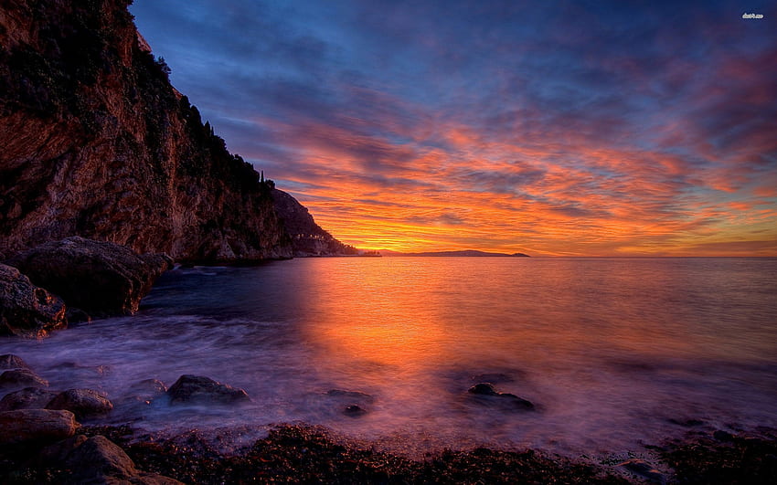 Peaceful ocean and the cloudy sunset sky by the rocky shore, Peaceful ...