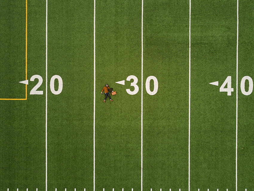 / drone aerial view of a person lying on the back on a football pitch in montreal, under 30 HD wallpaper