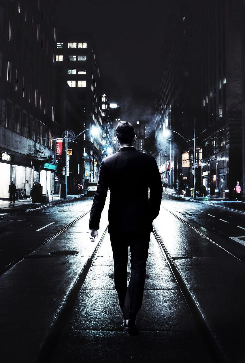 夜の通りを歩いているビジネス スーツを着た若い男 HD電話の壁紙