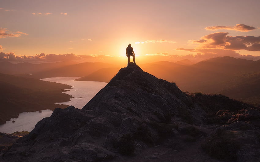 Homem de pé na ponta da montanha durante a hora de ouro papel de parede HD
