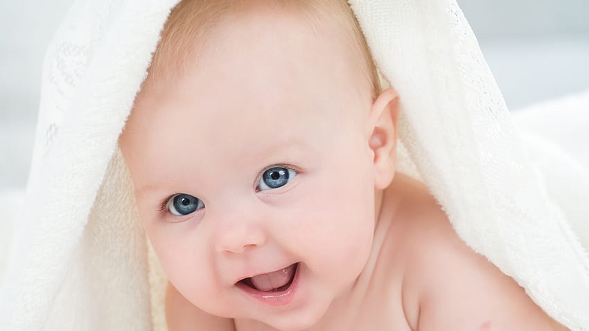 Blaue Augen niedliches lächelndes Kleinkind-Baby innerhalb des weißen Tuches niedlich HD-Hintergrundbild