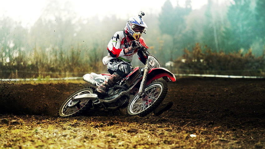 Um piloto de motocross em um fundo colorido.