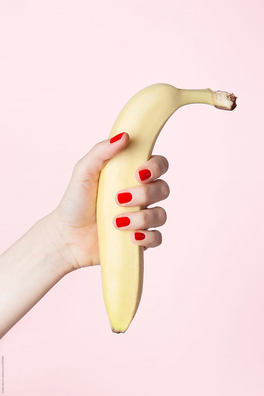 banana in female hand on pink background HD phone wallpaper