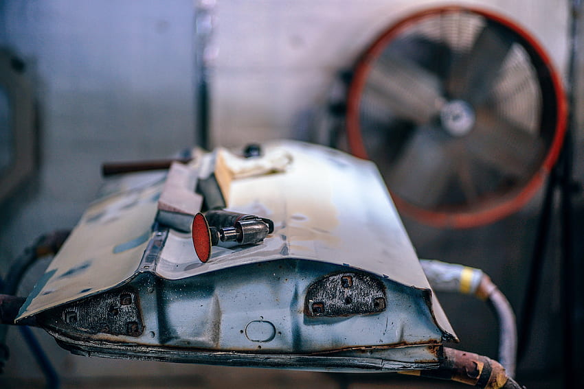 / ein metallschrottteil mit werkzeug darauf in einer garage mit ventilator, haushaltsgerät HD-Hintergrundbild