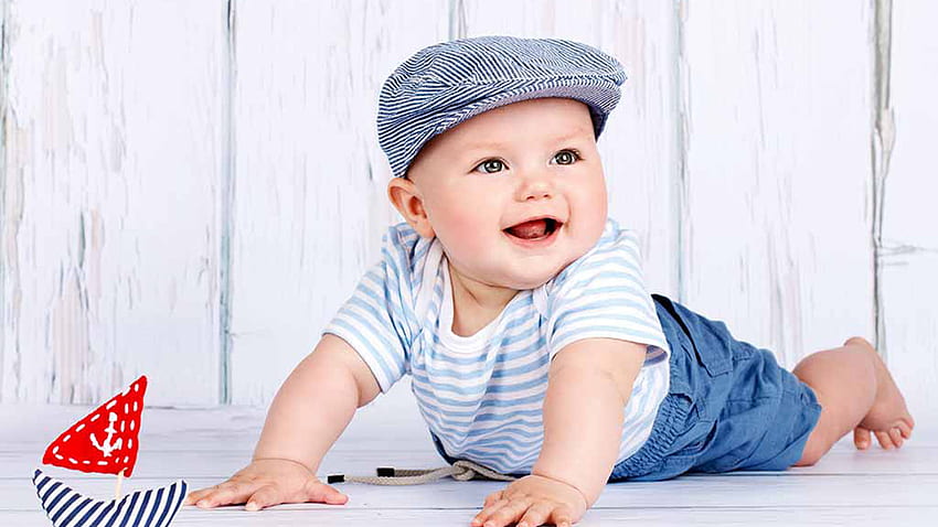 Усмихнато сладко момченце бебе лежи на пода, облечено в бяла синя рокля и шапка Момичета HD тапет