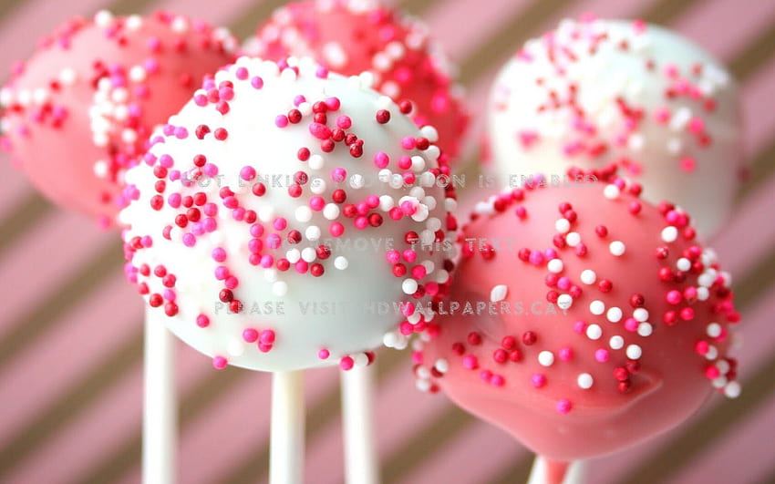 Sweet lollipops in form of hearts against pink background  Free Stock Photo