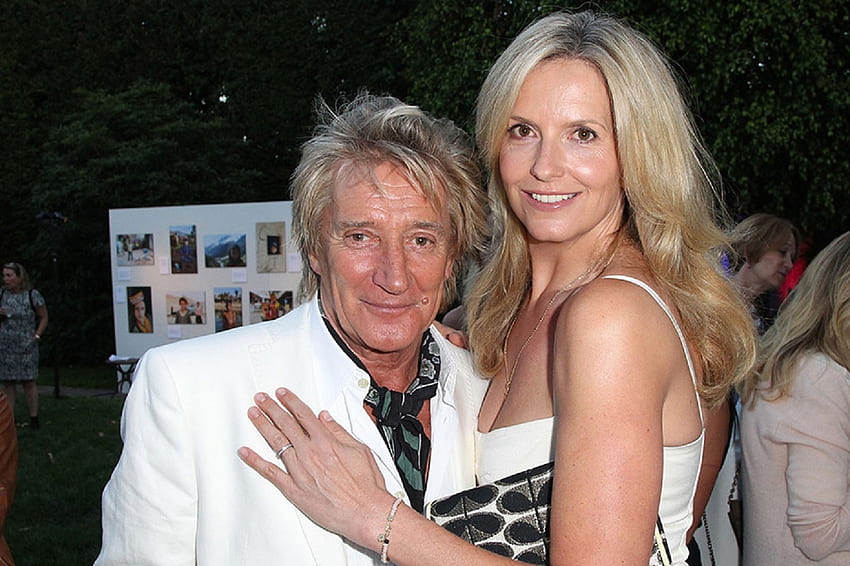 Happy Couple Penny Lancaster and Rod Stewart, Rod with white jacket, penny with white dress and bracelet, happy couple, handbag, trees, loose tie around neck HD wallpaper
