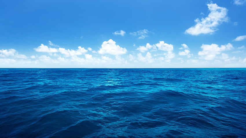 Océan d'un bleu profond avec un ciel bleu nuageux Fond d'écran HD