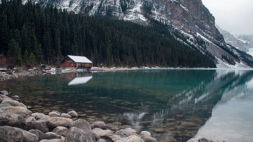 Пейзажен изглед на дървена къща, камъни върху езеро в дървета, планински фон, отражение върху природата на водата HD тапет