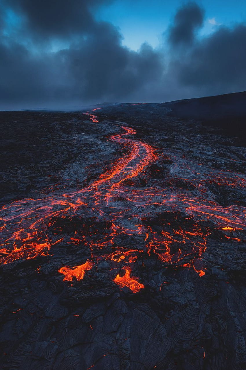 Flujo de lava, caliente y oscuro, montañas y volcanes. Volcán fondo de pantalla del teléfono