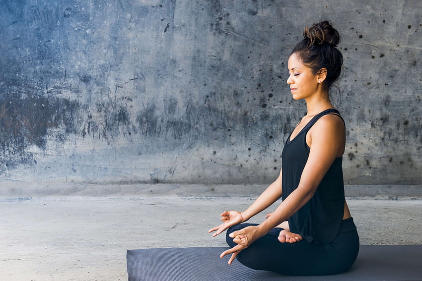 Una giovane donna vestita di nero facendo meditazione Yoga salute Sfondo HD