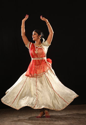 Free Photos - A Beautiful Indian Woman In A Pink And Gold Traditional  Outfit, Performing A Dance On Stage. Her Outfit Is Adorned With An Ornate  Vest, Complementing Her Graceful Dance Moves.
