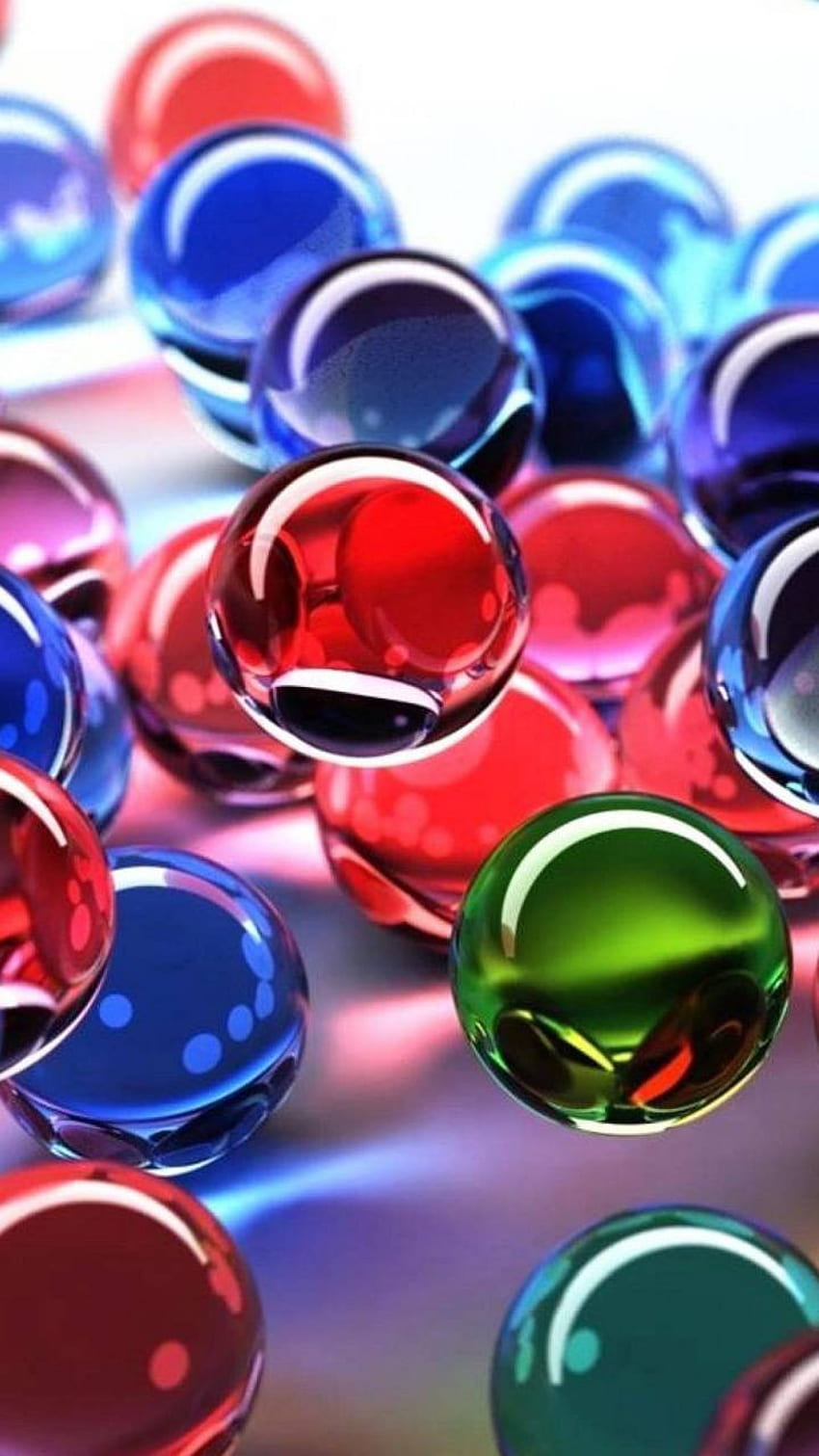 Un montón de canicas de vidrio con un fondo colorido