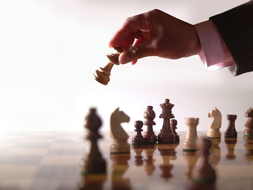 Cómo la estrategia competitiva puede dar forma a la sostenibilidad corporativa: tablero de ajedrez con mano y antecedentes, estrategia empresarial fondo de pantalla